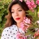 Avatar of woman taking a photo behind flowers